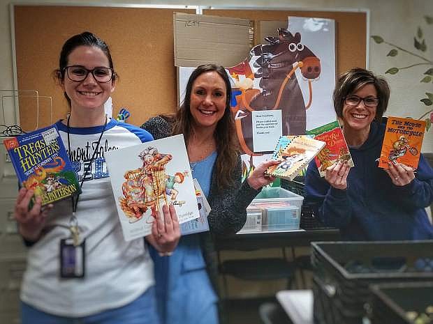 Sarah Ruiz, left, Shannon Slamon and Muriel Toyner of Fremont Elementary School display books recently donated to the campus.