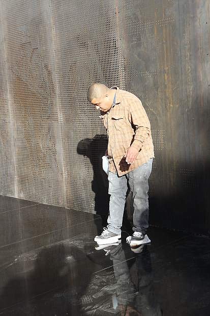Carlos Iniguez of Premier Tile and Stone goes across the new marble surface of the Battle Born Memorial honoring Nevada&#039;s fallen veterans, polishing it with cloths soaked in Acetone under his shoes.