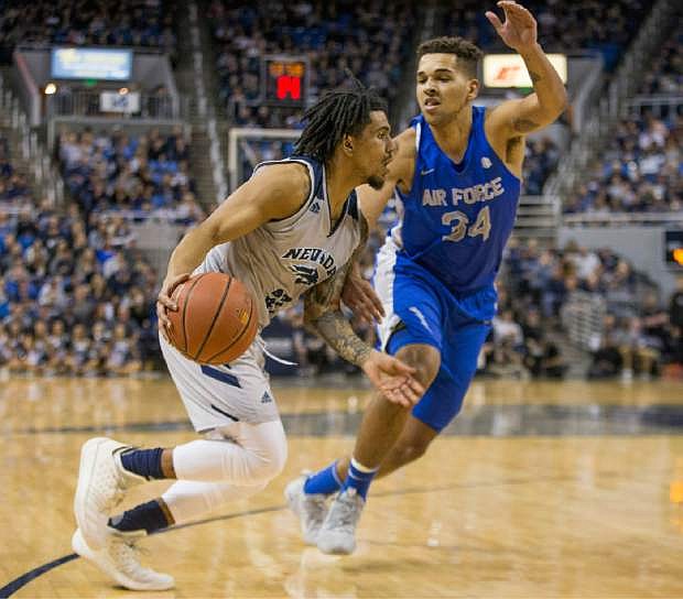 Nevada guard Jazz Johnson (22) drives the baseline against Air Force forward Ryan Swan (34) during the first half of an NCAA college basketball game in Reno, Nev., Saturday, Jan. 19, 2019. (AP Photo/Tom R. Smedes)