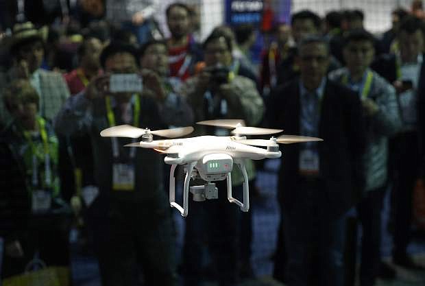 FILE - In this Jan. 7, 2016 file photo a drone hovers at the DJI booth during CES International in Las Vegas. The skies around Nevada&#039;s largest cities are about to see more drones, after federal agencies picked the state for testing remote-controlled aircraft in urban airspace. The Federal Aviation Administration and U.S. Department of Transportation announced Jan. 15, 2019, that the Nevada UAS Test Site Smart Silver State program will oversee testing in Reno and Henderson.(AP Photo/John Locher, File)