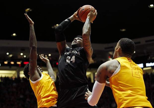 Nevada forward Jordan Caroline, center, goes up for a shot as New Mexico&#039;s Corey Manigault, left, and Vance Jackson defend during the first half Saturday in Albuquerque, N.M.