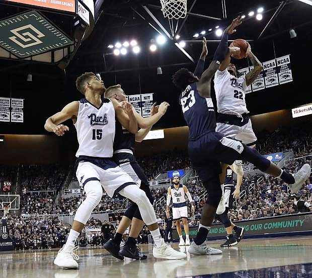 Nevada&#039;s Jazz Johnson goes up to the basket against Utah State while teammate Trey Porter converges in the first half on Wednesday at Lawlor Events Center.