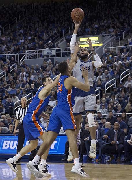 Nevada forward Cody Martin, right, shoots over the Boise State defense in the first half of an NCAA college basketball game in Reno, Nev., Saturday, Feb. 2, 2019. (AP Photo/Tom R. Smedes)