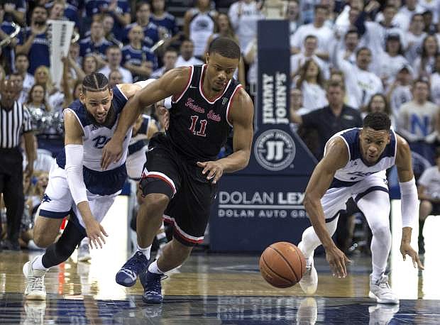 Fresno State guard Christian Gray (11), Nevada forward Cody Martin, left, and forward Tre&#039;Shawn Thurman, right, scramble for a loose ball in the second half of an NCAA college basketball game in Reno, Nev., Saturday, Feb. 23, 2019. (AP Photo/Tom R. Smedes)