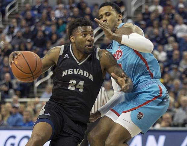Nevada forward Jordan Caroline (24) drives past New Mexico guard Vance Jackson (2) in the first half of an NCAA college basketball game in Reno, Nev., Saturday, Feb. 9, 2019. (AP Photo/Tom R. Smedes)