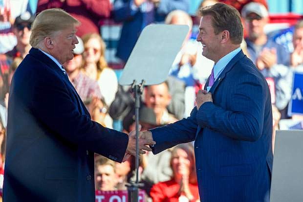FILE - In this Oct. 20, 2018, file photo, President Donald Trump and U.S. Sen. Dean Heller, R-Nev., shake hands at a campaign rally in Elko, Nev. President Trump says former Nevada Sen. Heller lost his re-election because he was &quot;extremely hostile&quot; to Trump during the 2016 election and that he didn&#039;t pick Heller to be U.S. Interior Secretary because he couldn&#039;t get his base excited about the Republican, the Las Vegas Review-Journal reports. (AP Photo/Alex Goodlett, File)