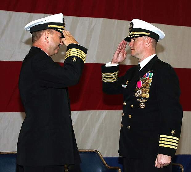 Capt. David Halloran, outgoing commanding officer of Naval Air Station Fallon, right, turns over command to Capt. Evan Morrison during a change of command ceremony held in hangar seven on the base.