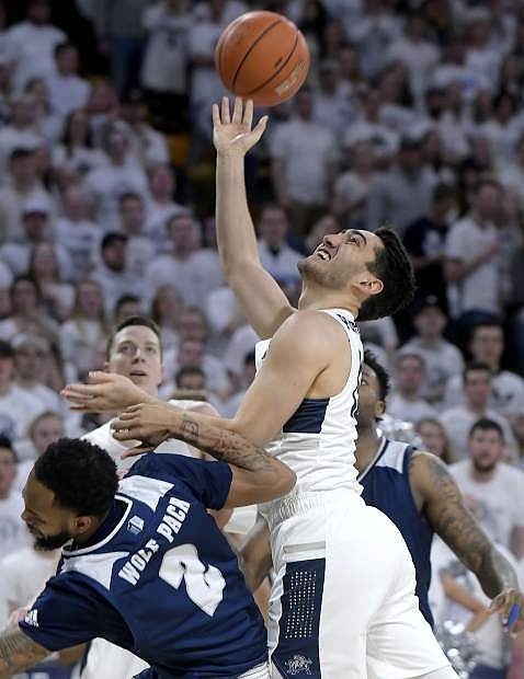 Utah State guard Abel Porter takes a shot while being fouled by Nevada guard Corey Henson (2) during an NCAA college basketball game, Saturday, March 2, 2019, in Logan, Utah. (Eli Lucero/The Herald Journal via AP)