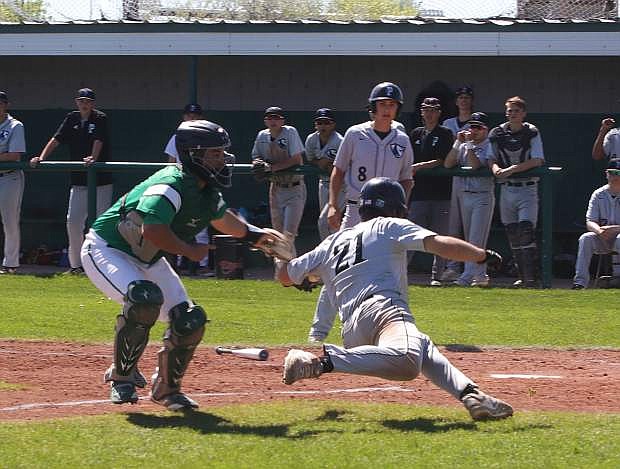 North Valleys Jace Miller (21) avoids a tag at home plate from Fallon catcher Edgar Alvarado.