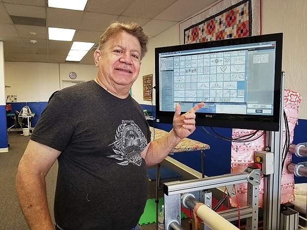 Paul Schwartz shows the computer screen displaying various stitching patterns for finishing a quilt.
