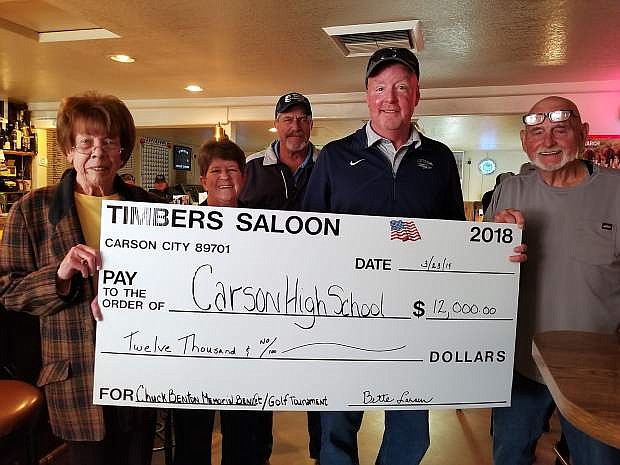 Bette Larsen, owner, Timbers Saloon, and Julie Benton, Rich Lawlor, David Benton, and Tom Benton present a $12,000 check for the first Chuck Benton Memorial scholarship at Timbers Saloon on March 23.
