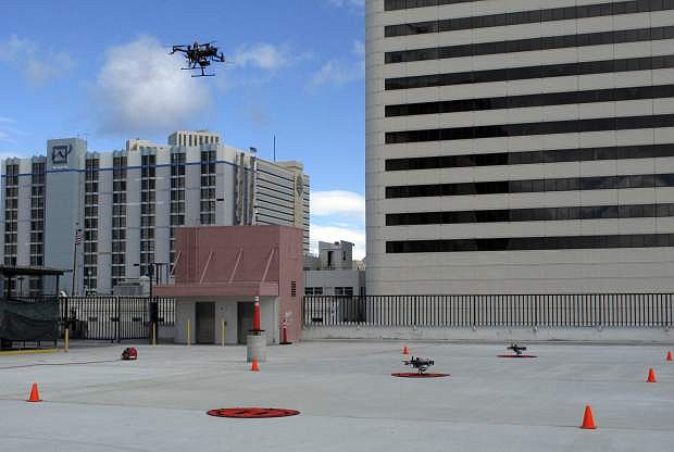 In this Tuesday, May 21, 2019 photo, a drone takes off from the roof of the Cal-Neva casino parking garage in downtown Reno, Nev. as part of a NASA simulation to test emerging technology that someday will be used to manage travel of hundreds of thousands of commercial, unmanned aerial vehicles (UAVs) delivering packages. It marked the first time such tests have been conducted in an urban setting. (AP Photo/Scott Sonner)