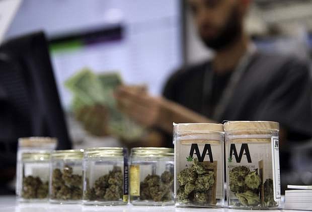 FILE - In this July 1, 2017 file photo, a cashier rings up a marijuana sale at the Essence cannabis dispensary in Las Vegas. Some marijuana businesses turned away when Nevada awarded 61 new dispensary licenses last December are ratcheting up pressure in court for the state to redo the selection process. (AP Photo/John Locher, File)