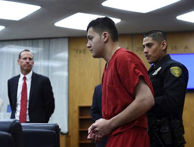 Washoe County District Attorney Christopher Hicks, left, looks on as Wilber Martinez-Guzman, from El Salvador, appears in Washoe District Court in Reno, Nev., on Monday, May 20, 2019. Martinez-Guzman faces murder, burglary and weapons charges in the deaths of four people in northern Nevada in January. (Andy Barron/Reno Gazette-Journal via AP, Pool)