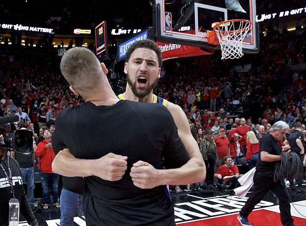Golden State guard Klay Thompson hugs forward Jonas Jerebko at the end of Game 4 of the Western Conference finals against Portland on May 20.