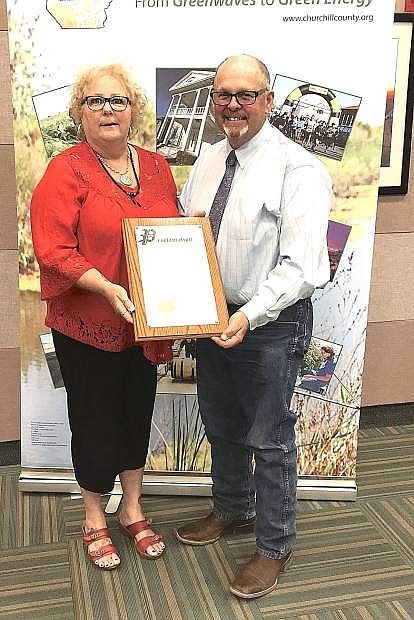 Commissioner Pete Olsen presents a proclamation to Lisa Erquiaga, director of the William N. Pennington Life Center recognizing May as Older Americans Month.