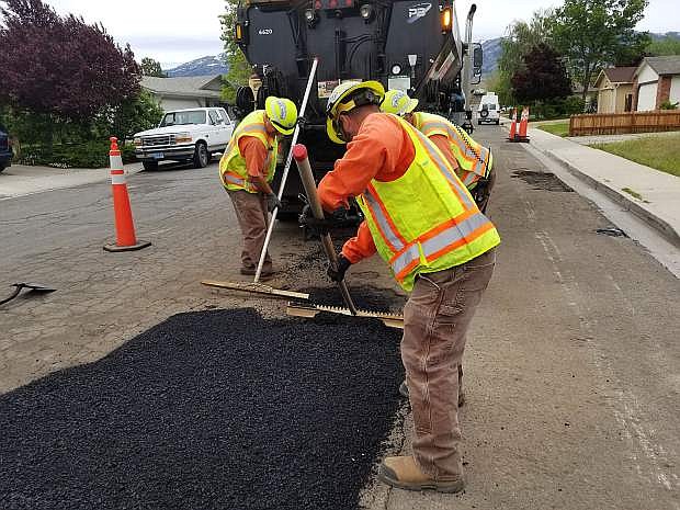Public Works staff fills a large pothole on Slide Mountain Drive with asphalt.