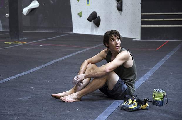 In this June 18, 2019, photo, professional rock climber Alex Honnold sits on the padded floor at the Earth Treks gym in Englewood, Colo. Honnold is trying to get a grip on life in the aftermath of the Academy Award winning documentary &quot;Free Solo.&quot; His fear is that maybe his 2017 ropeless climb of El Capitan in Yosemite featured in the spine-tingling film just might be the summit of his career. (AP Photo/Thomas Peipert)