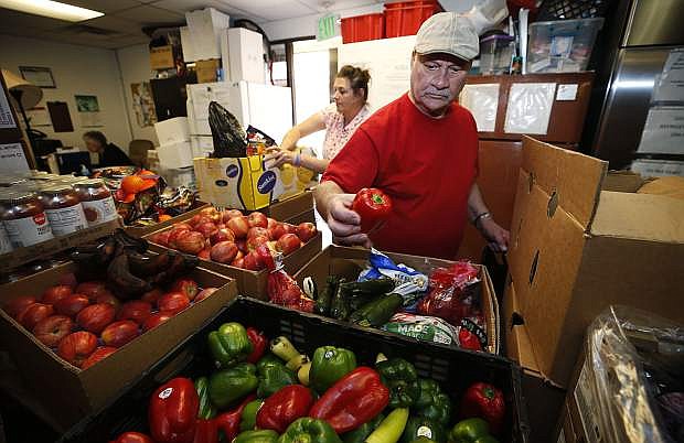 With the help of volunteer Minnette Schrader, Steve Urrutia picks up food at the Ron Wood Family Resource Center food bank in Carson City on May 3.