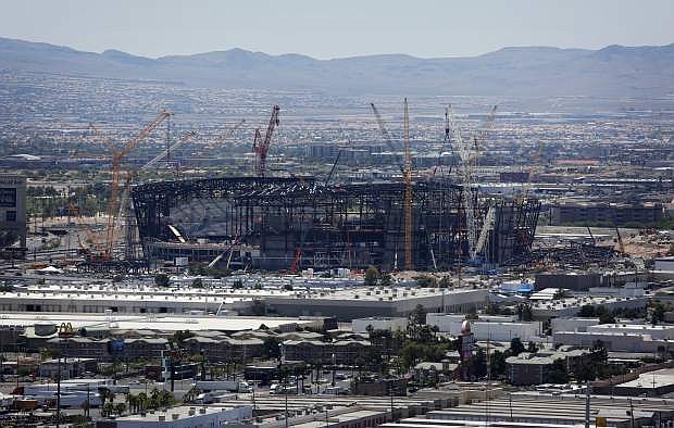 FILE - In this June 4, 2019, file photo, construction cranes surround the football stadium under construction in Las Vegas. Officials in Las Vegas have boosted the cost of a 65,000-seat stadium being built for the NFL&#039;s relocated Raiders and UNLV football to $1.9 billion. The Las Vegas Review-Journal reports the Las Vegas Stadium Authority board on Thursday, July 18, 2019, approved $40 million in additions. They include 20 more suites and a field-level club area to be paid for by personal seat license and club seat sales not part of the original budget. (AP Photo/John Locher, File)