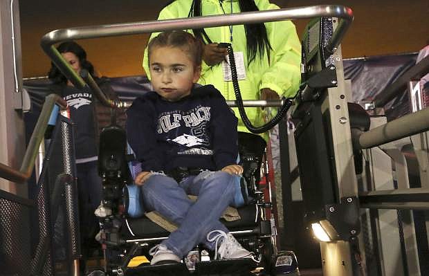 This photo taken Oct. 13, 2018 shows 7-year old Ella Marini getting loaded onto a special lift as she makes her way into Mackay Stadium to see Nevada take on Boise State in Reno, Nev. Lawyers for the University of Nevada, Reno are asking the state&#039;s board of regents to authorize a lawsuit against architects they blame for a botched renovation project that left the school&#039;s football stadium in violation of the Americans with Disability Act. (Jason Bean/The Reno Gazette-Journal via AP)