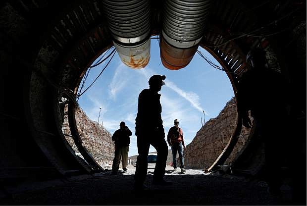 FILE - In this April 9, 2015, file photo, people walk into the south portal of Yucca Mountain during a congressional tour of the proposed radioactive waste dump near Mercury, Nev., 90 miles northwest of Las Vegas. Recent California earthquakes that rattled Las Vegas have shaken up arguments by proponents and opponents of a stalled federal plan to entomb nuclear waste beneath a long-studied former volcanic ridge in southern Nevada.