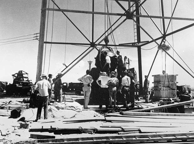 FILE - In this July 6, 1945, file photo, scientists and workmen rig the world&#039;s first atomic bomb to raise it up onto a 100 foot tower at the Trinity bomb test site near Alamagordo, N.M. A compensation program for those exposed to radiation from years of nuclear weapons testing and uranium mining would be expanded under legislation that seeks to address fallout across the western United States, Guam and the Northern Mariana Islands.(AP Photo/File )