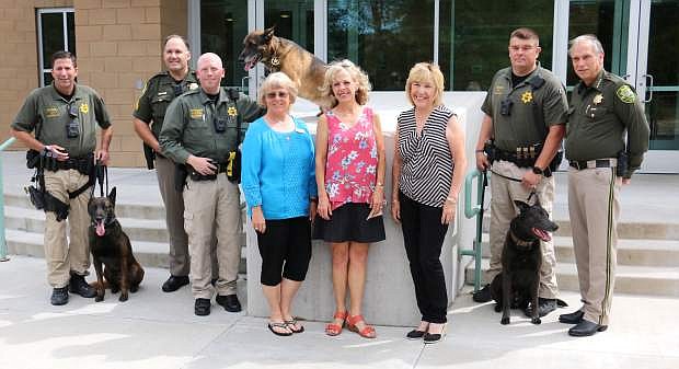 Carson Animal Services Initiative representatives, including chair Lisa Schuette, center, presented a $6,000 donation to the Carson City Sheriff&#039;s Office K-9 program Wednesday to provide safety equipment and first aid care for its five dogs. Three of the dogs, including Tico, left, with handler Deputy Jimmy Surratt, Tarzan, center, with handler Deputy Darin Riggin and Blue, with handler Deputy Jeff Pullen to the left of Sheriff Kenny Furlong, gathered for the donation.