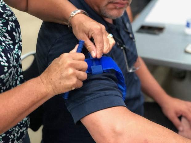 Carson High School Vice Principal Marc Rodina has a tourniquet placed on his arm by school district chief nurse Sheila Story at Thursday&#039;s Emergency Operations Plan training meeting at Fuji Park.