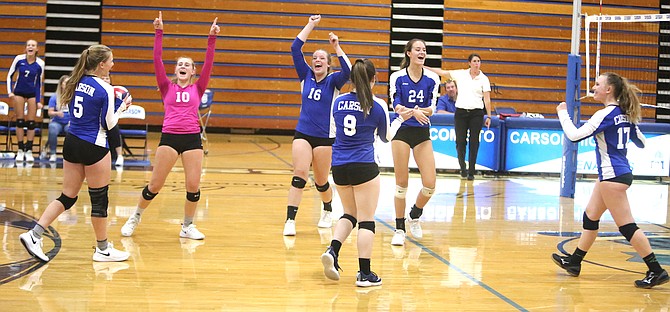 The Carson girls volleyball team celebrates after winning the final points against Reed Tuesday night. 