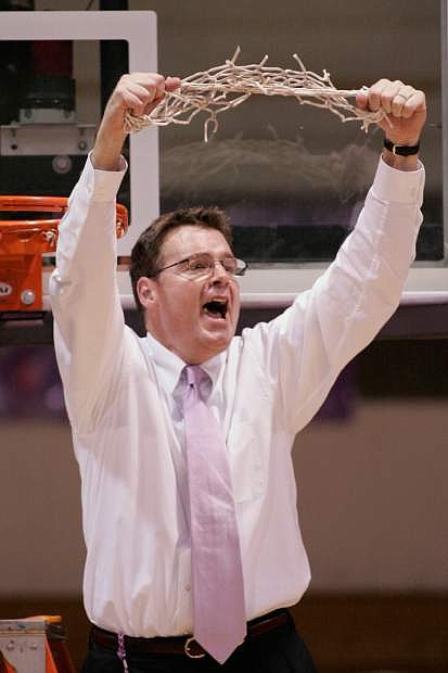 FILE - In this March 7, 2007, file photo, Holy Cross coach Bill Gibbons raises the net above his head after Holy Cross defeated American University 56-48 in the championship game of the Patriot League women&#039;s basketball tournament, in Worcester, Mass. The former coach of the Holy Cross women&#039;s basketball team who was fired in March after 34 years has sued the school, alleging breach of contract, defamation, age discrimination, infliction of emotional distress and other wrongdoing.