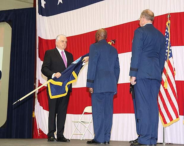 Gov. Steve Sisolak, left, prepares to pass the guidon to incoming Adjutant General Ondra Berry, center. Brig. Gen. William Burks, let, is the outgoing adjutant general.