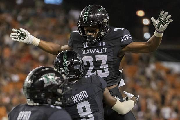 Hawaii wide receiver JoJo Ward (9) lifts his teammate wide receiver Jared Smart (23) celebrating his touch down reception during the second half of an NCAA college football game against Oregon State, Saturday, Sept. 7, 2019, in Honolulu. (AP Photo/Eugene Tanner)