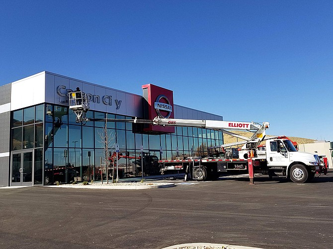 Workers place the sign on the new Carson City Nissan car dealership on South Carson Street scheduled to open the first week in November.