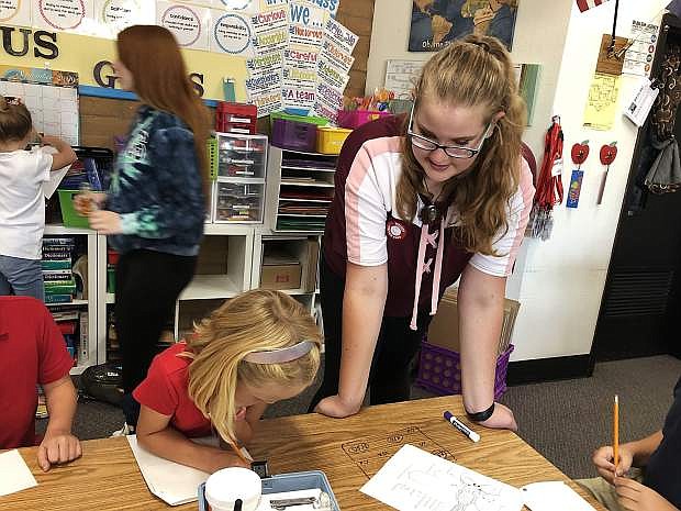 Grace, Pioneer High School student, prepares Seeliger Elementary students in the classroom for field experiments.