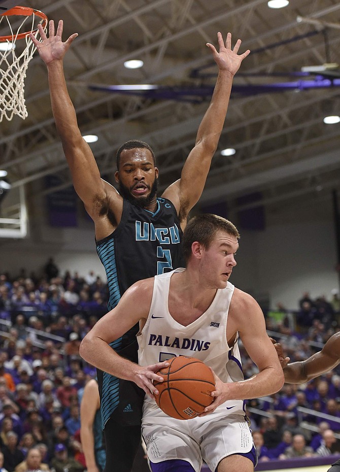 FILE - In this Dec. 15, 2018. file photo, Furman&#039;s Matt Rafferty works against North Carolina Wilmington&#039;s Jeantal Cylla during the first half of an NCAA college basketball game in Greenville, S.C. Eric Musselman, the new coach at Arkansas, relied heavily on transfers at Nevada and bolstered his new team with graduate transfers Cylla from UNC Wilmington and Jimmy Whitt Jr.