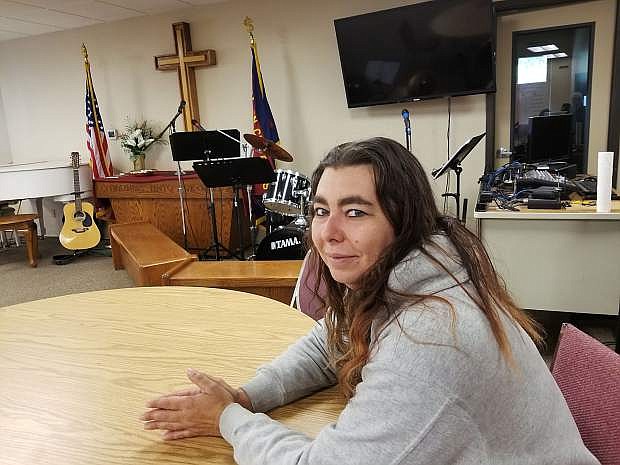 Christie Contreras, the Salvation Army&#039;s office coordinator, sits at a table in the large room that doubles as a chapel and youth programs location.