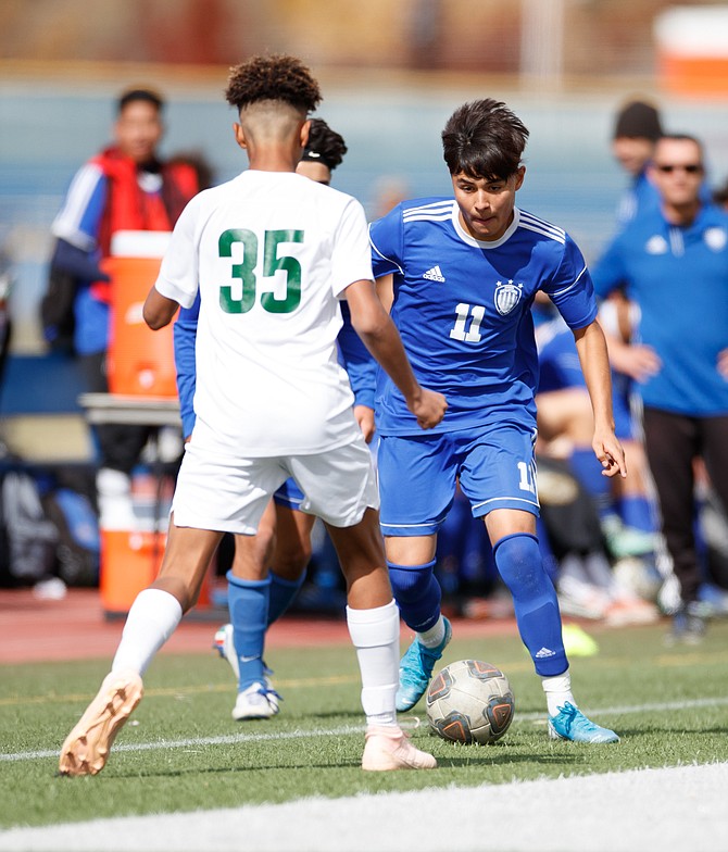 Carson&#039;s Christofer Palacio Nevarez dribbles against Manogue&#039;s Dominik Chipp during the NIAA Northern Division 1 soccer match between the Bishop Manogue Miners and Carson High Senators at Carson High School.