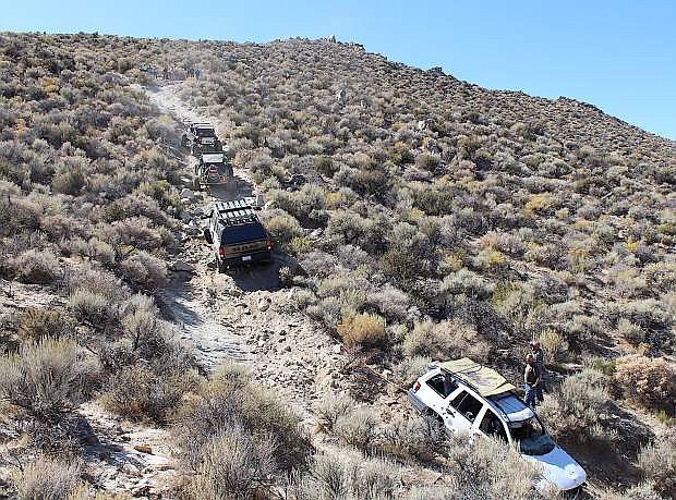 Off-road vehicles form a chain to get an abandoned Jeep Liberty out of Dead Truck Canyon.