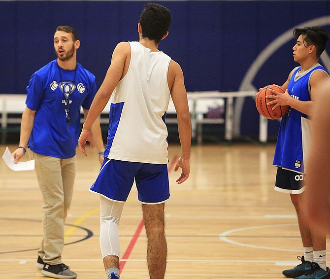 Carson High boys basketball coach Jordan Glover walks through instructions during practice Friday as Bryan Peralta, right, and Parsa Hadjighasemi, middle, look on. Glover and the Senators open their season Saturday at Foresthill High School in California.