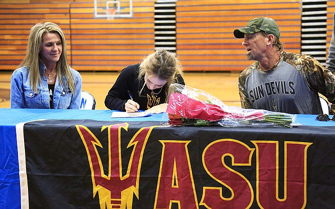 Carson High&#039;s Kailee Luschar, center, signs her National Letter of Intent to play softball at Arizona State Friday afternoon, following her senior season with the Senators. Pictured with Kailee are her parents, Judy, left, and Steve, right.