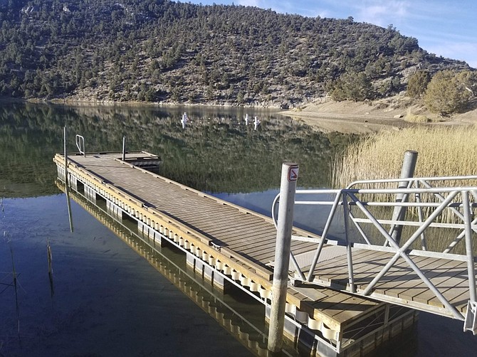 This photo taken Wednesday, Nov. 6, 2019 and provided by the Nevada Division of State Parks, shows a boat dock at Cave Lake, a reservoir that was created by the construction of the Cave Creek Dam in 1932, at Cave Lake State Park about 15 miles southeast of Ely, Nev. A $3.4 rehabilitation project is planned at the dam, which is one of 14 in Nevada that is rated to be a high hazard and in poor or unsatisfactory condition. (Steve Gray/Nevada Division of State Parks via AP)