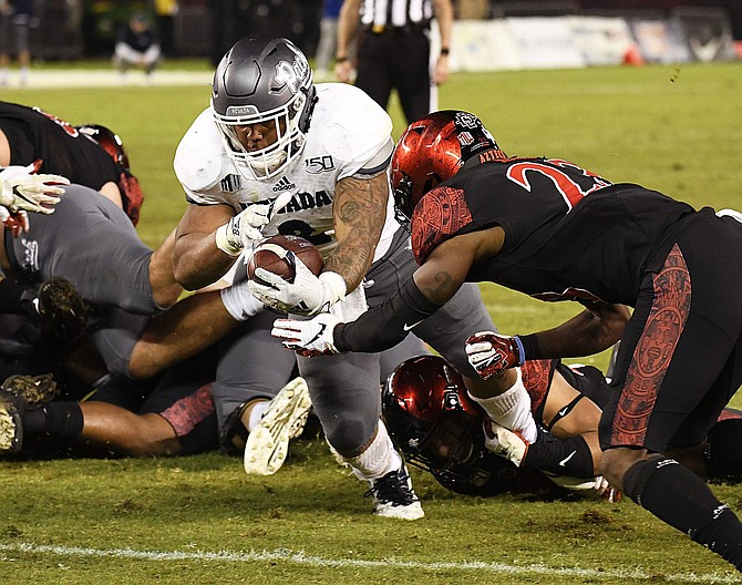 Nevada running back Devonte Lee (2) dives into the end zone past the defense of San Diego State cornerback Darren Hall (23) during the second half of an NCAA college football game Saturday, Nov. 9, 2019, in San Diego. (AP Photo/Denis Poroy)