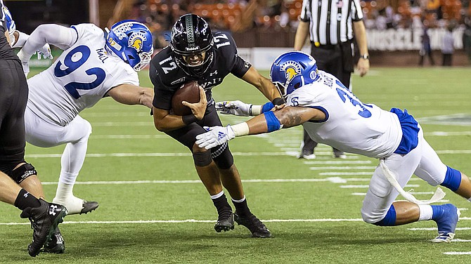 Hawaii quarterback Chevan Cordeiro (12) sees an opening in the San Jose State defense and runs for a touchdown in the second half Saturday in Honolulu. Hawaii beat San Jose 42-40.