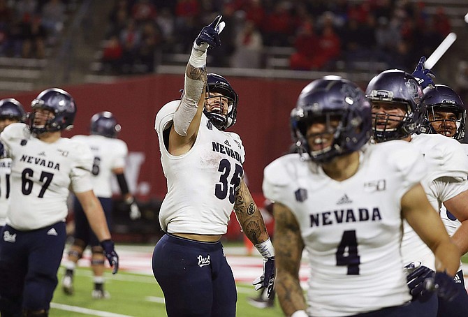 Nevada running back Toa Taua celebrates with teammates after scoring the winning touchdown against Fresno State during the second half of an NCAA college football game in Fresno, Calif., Saturday, Nov. 23, 2019. (AP Photo/Gary Kazanjian)