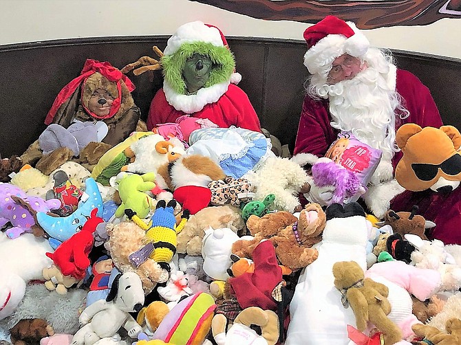 Santa, the Grinch, and Max sit among the many donated stuffed toys to be given to children at the Carson Nugget on Dec. 6.