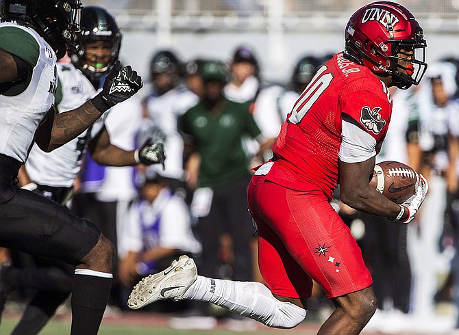 UNLV wide receiver Darren Woods Jr. (10) makes a catch and runs for a touchdown past Hawaii defensive backs Rojesterman Farris II (4) and Eugene Ford (8) in the first quarter of an NCAA college football game Saturday, Nov. 16, 2019, in Las Vegas. (Benjamin Hager/Las Vegas Review-Journal via AP)