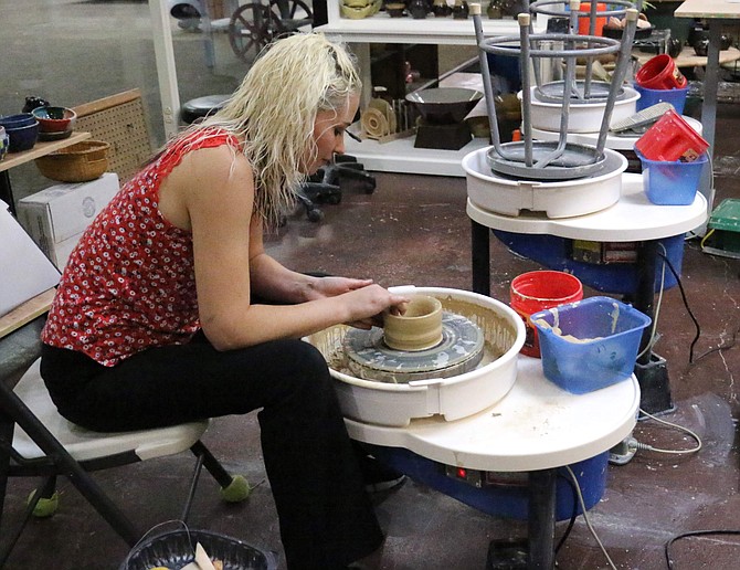 Chelsea Lavender, chairman of Ogres-Holm Pottery, demonstrates working on a pottery wheel at the studio in the Carson Mall. The staff offers a dedicated night every Tuesday for community members to create bowls for the upcoming &quot;Empty Bowls&quot; event on Dec. 7.