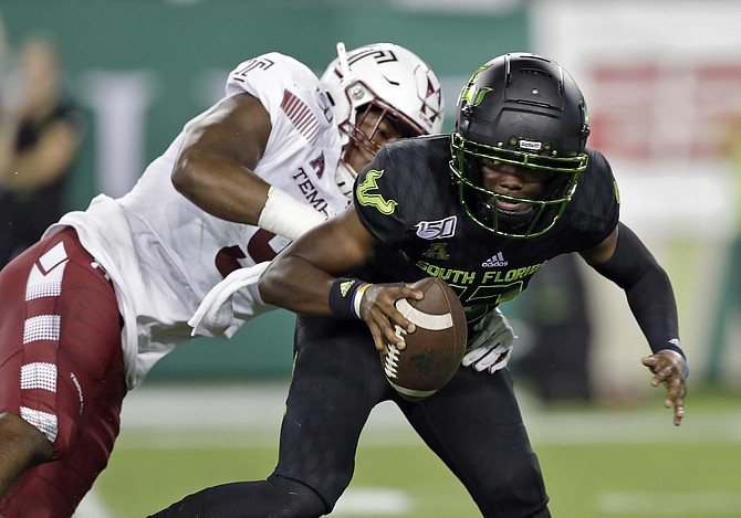 File-This Nov. 7, 2019, file photo shows South Florida quarterback Jordan McCloud (12) eluding a sack by Temple defensive end Quincy Roche during the first half of an NCAA college football game in Tampa, Fla. Roche was named American Athletic Conference Defensive Player of the Year after ringing up 13 sacks, including 10 in the Owls&#039; final four games. In a pivotal victory over then No. 21 Maryland, the 6-foot-4, 235-pounder had a sack, a blocked kick and six tackles. (AP Photo/Chris O&#039;Meara, File)