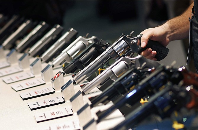 FILE - In this Jan. 19, 2016 file photo, handguns are displayed at the Shooting, Hunting and Outdoor Trade Show in Las Vegas. Leaders of a conservative advocacy group want quick action from a Nevada judge to block enactment of a statewide &quot;red flag&quot; gun law that will let courts on Jan. 2, 2020, order firearms to be taken from people deemed to be a threat to themselves or others. (AP Photo/John Locher, File)